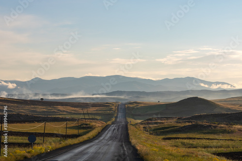 Countryroad at sunrise. Road in the field. Agricultural fields and the road.