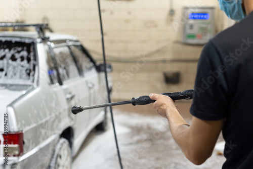 coronavirus cleaning of the car, washing the car body with a kersher from soap solution. The work of auto technicians during the quarantine period covid 19