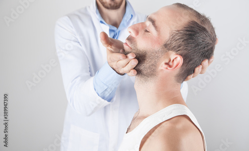 Caucasian doctor massaging patient head.