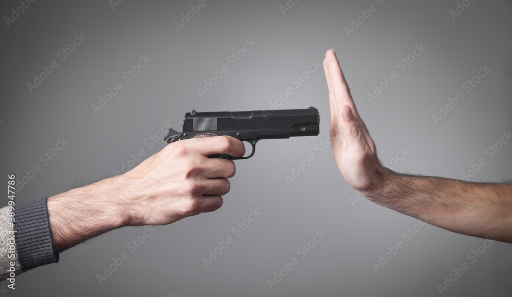 Hand pointed with a gun at a person. Stop War Hand pointed with a gun at a person. Stop War