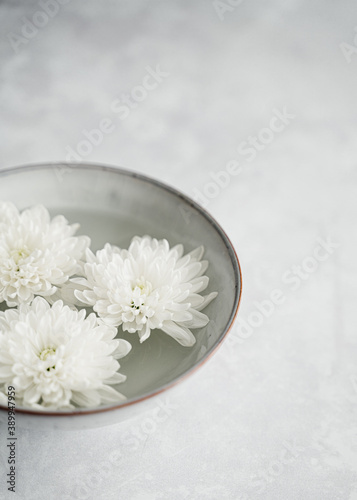 white flower in a bowl on grey background