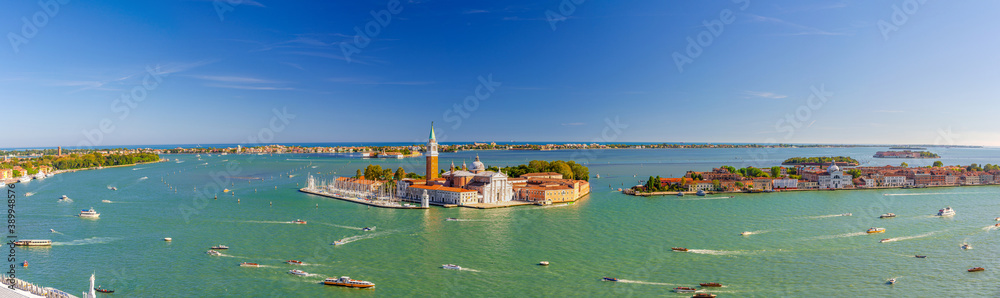 Aerial panoramic view of Venetian Lagoon with San Giorgio Maggiore island, Lido island and Giudecca island, sailing boats in Giudecca Canal, blue sky, Venice city, Italy. Panoram of Venetian Lagoon