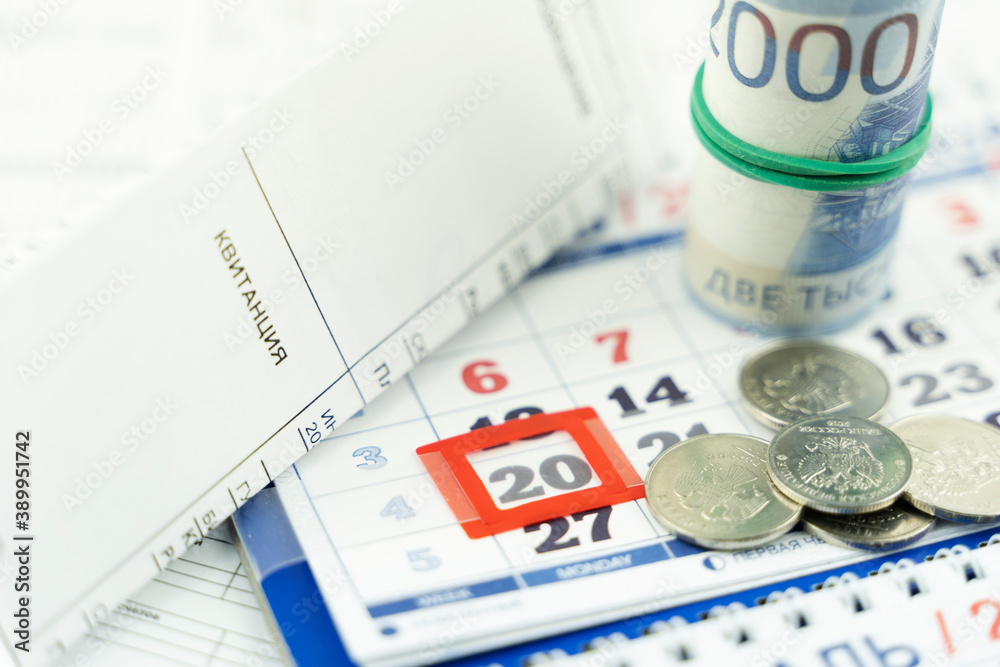 Fototapeta premium a receipt for the utilities in the background of the calendar. the concept of higher taxes for utilities translation of 