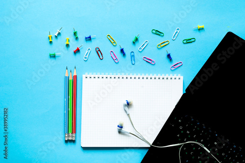 Laptop and Stationery supplies on blue background. Back to school or Distance learning in quarantine. Creative copy space.