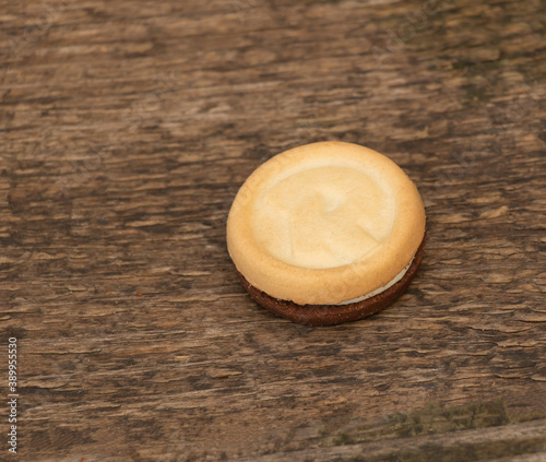 Three flavors in a single biscuit, two sides and a delicious cream in the middle. On wooden background