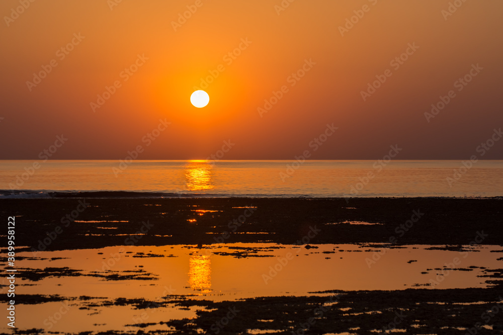 warm orange sun at the horizon from the sea in the morning