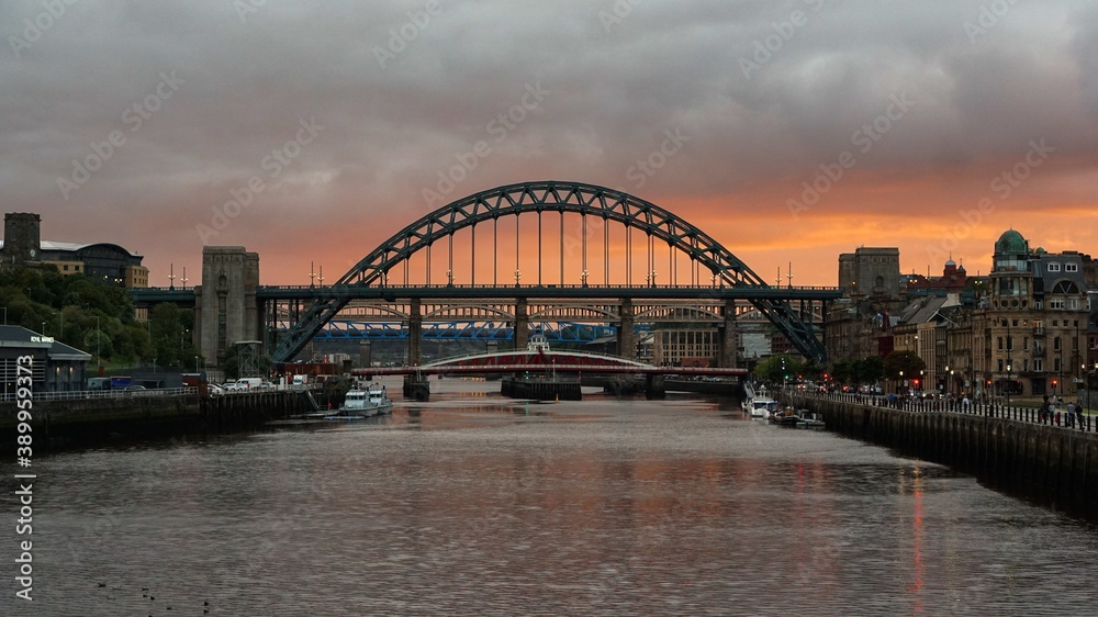 Sunset over the river Tyne in Newcastle upon Tyne, orange clouds behind the Tyne and the Swing bridges