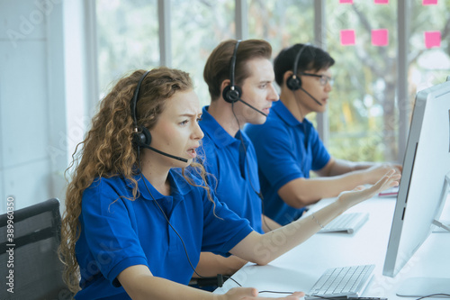 Confident customer service agents with headset working in the office.