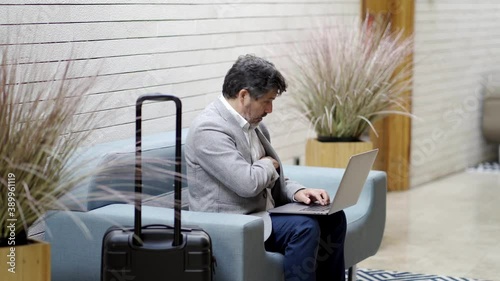 A businessman works with the laptop in a lobby hotel 