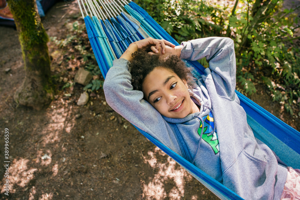Happy, smiling girl relaxing in hammock in forest campground Happy, smiling girl relaxing in hammock in forest campground