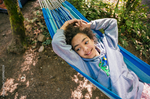 Happy, smiling girl relaxing in hammock in forest campground