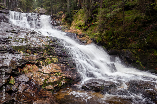 spectacular long waterfall in the forest  water cascades over the rocks  bohemian forest