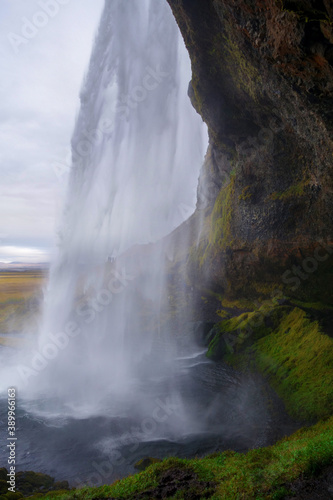 A view from behind the Seljalandsfoss waterfall in Iceland on a gloomy day.