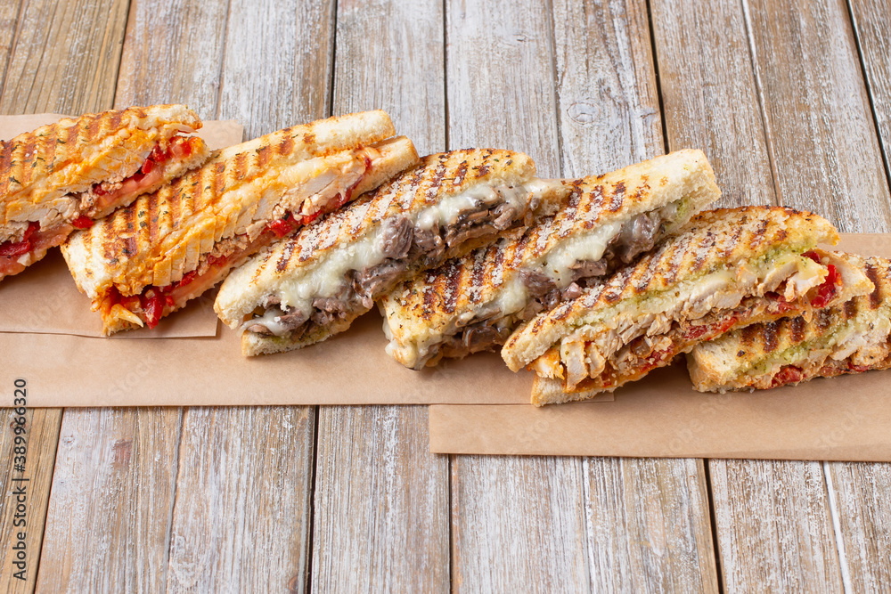 A view of several slices of panini sandwiches on a wooden surface.