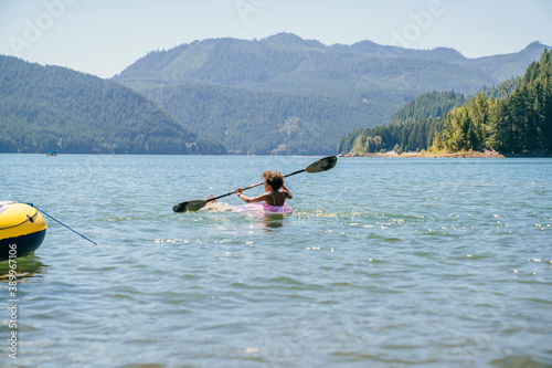Teen girl paddling on lake in inflatable pool floaty