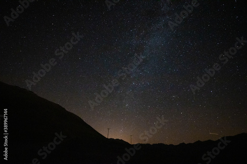 Milkyway ends on the horizon with poles of electricity line and a liitle light pollution