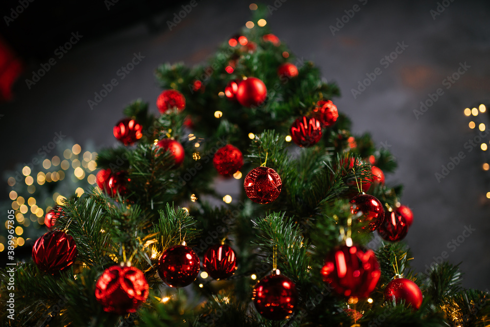 New Year 2021 interior with candles, bulbs and bokeh. Room decorated to christmas celebration. Christmas tree with presents