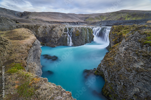 Icelandic waterfalls without tourists  azure blue surface  waters  in the middle of a desolate volcanic desert  rugged landscape with a magical waterfall