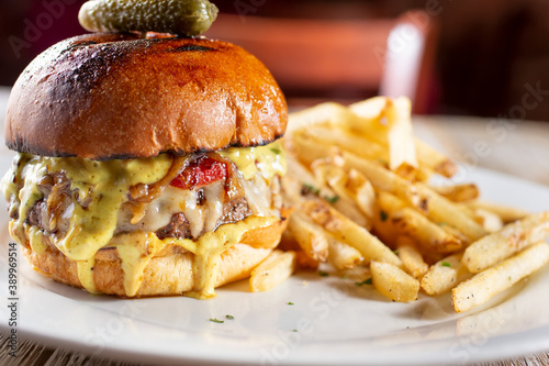 A view of a gourmet cheeseburger with a side of french fries.