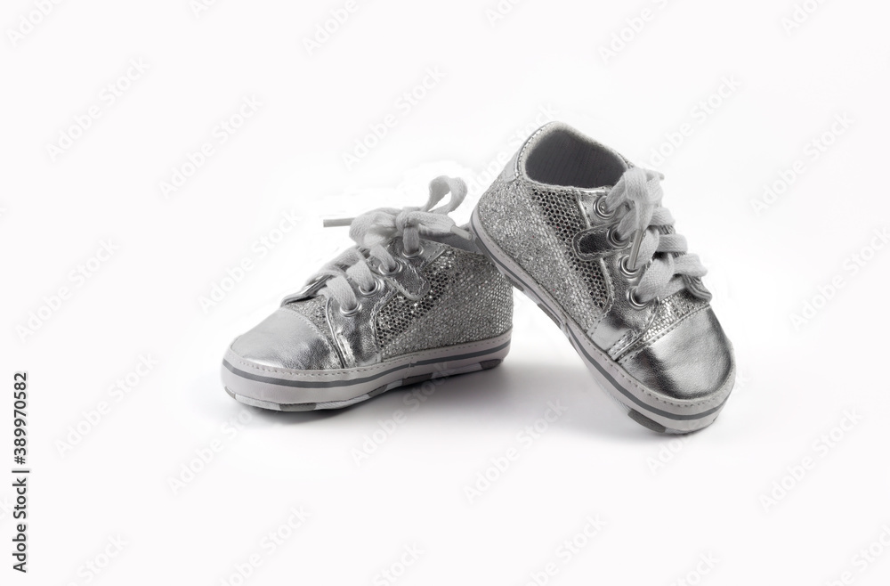 Children's sparkling little sneakers on white background