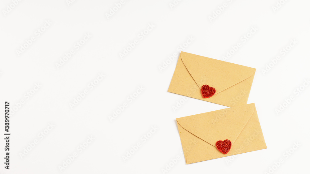 Two envilopes of craft paper with decorative hearts on the white background, isolated. Mock-up photo for any note for Sant Valentine's day.