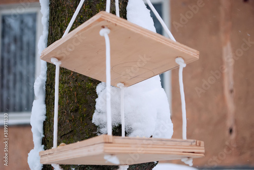 Wooden bird feeder in winter.