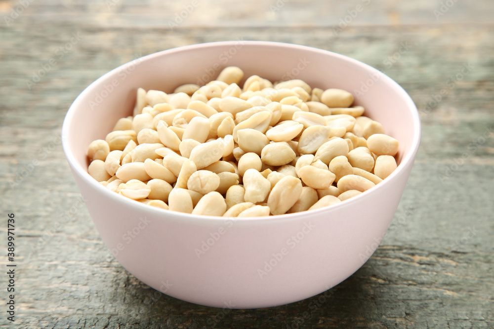 Peanuts in bowl on grey wooden table