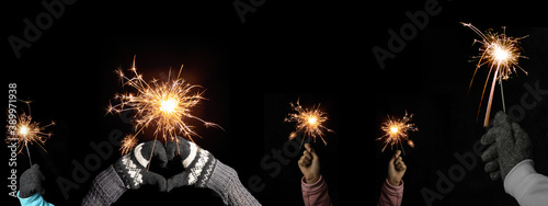Happy New Year / Silvester / Party background banner greeting card - Young family with two children holding sparkling sparklers in her hands at dark night