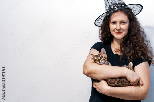 Woman in magic hat. Bengal cat.