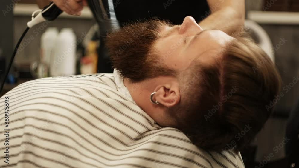 Professional care for a beard. The barber blows away her cropped hair. Trendy beard trim, takes care of themselves. Professional care for a beard. The barber blows away her cropped hair. Trendy beard trim, takes care of themselves.