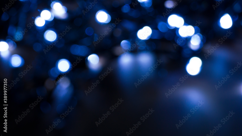 Light effect on a dark background, bright lights, blur, bokeh. Reflection of neon light in water.