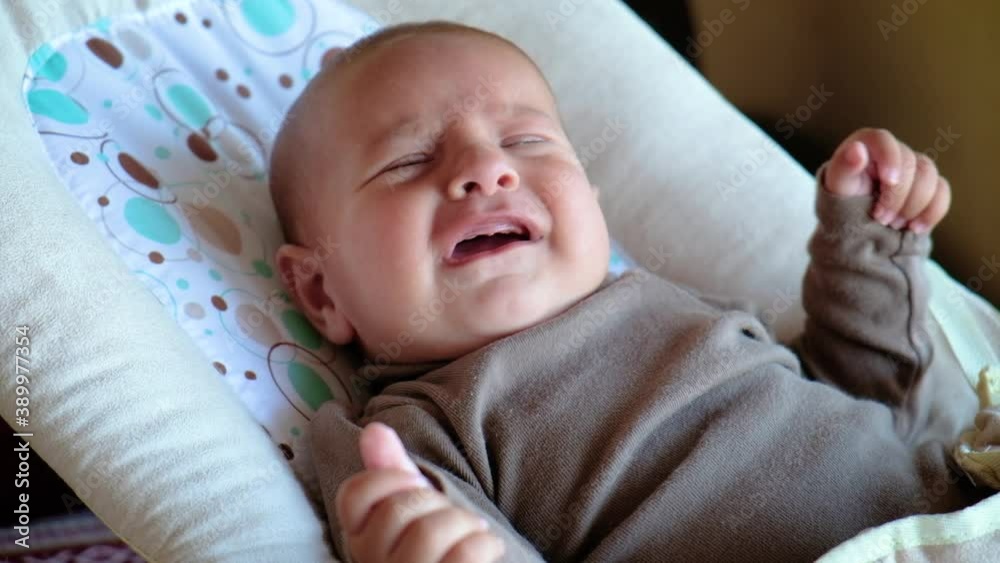 Close-up newborn baby crying in a baby rocking chair Close-up newborn baby crying in a baby rocking chair