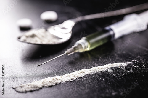 cocaine and heroin on dark wooden table, concept of addiction and chemical dependency, illegal drugs photo