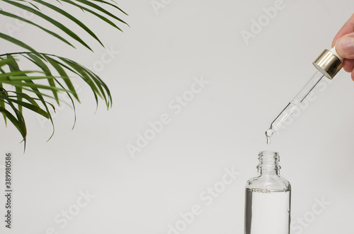 Female hands dropping serum collagen moisturizer. Protector skin facial treatment essence oil, Vitamin C. Beauty health care cosmetics concept.