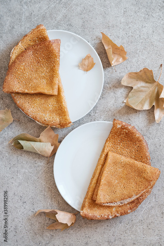 Pancakes in white plates on gray background