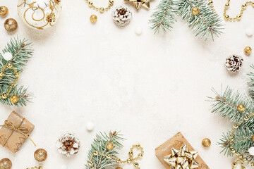 Christmas mood frame of gifts, green spruce, gold christmas decorations on white background. Copy space. New Year.