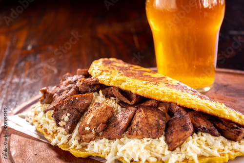 Venezuelan cachapa with pork and a glass of beer photo