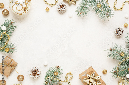 Christmas mood frame of gifts, green spruce, gold christmas decorations on white background. Copy space. New Year.