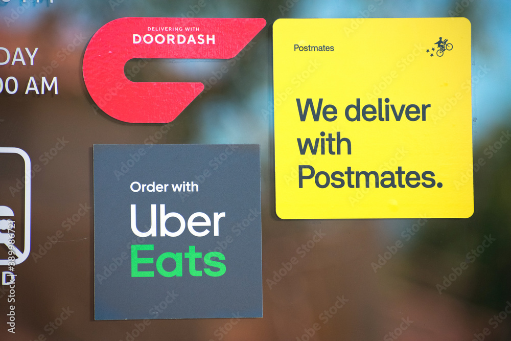 DoorDash, Postmates and Uber Eats stickers decal on a restaurant door