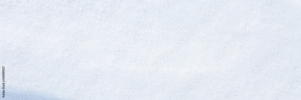 Beautiful winter background with snowy ground. Natural snow texture. Wind sculpted patterns on snow surface. Wide panoramic texture for background and design. Closeup top view with copy space. Beautiful winter background with snowy ground. Natural snow texture. Wind sculpted patterns on snow surface. Wide panoramic texture for background and design. Closeup top view with copy space.
