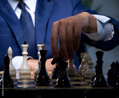 Fotografie Businessman playing chess in strategy concept