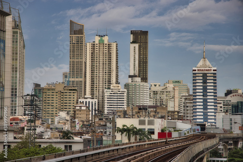 This unique photo shows the skyline of Bangkok in Thailand including the skytrain railroad track in the foreground and the skyscrapers.