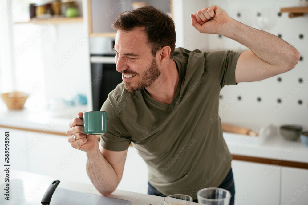 Handsome man preparing breakfast at home. Young man enjoying in morning Handsome man preparing breakfast at home. Young man enjoying in morning
