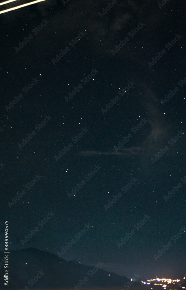night sky with stars with a mountain and a town low night sky with stars with a mountain and a town low