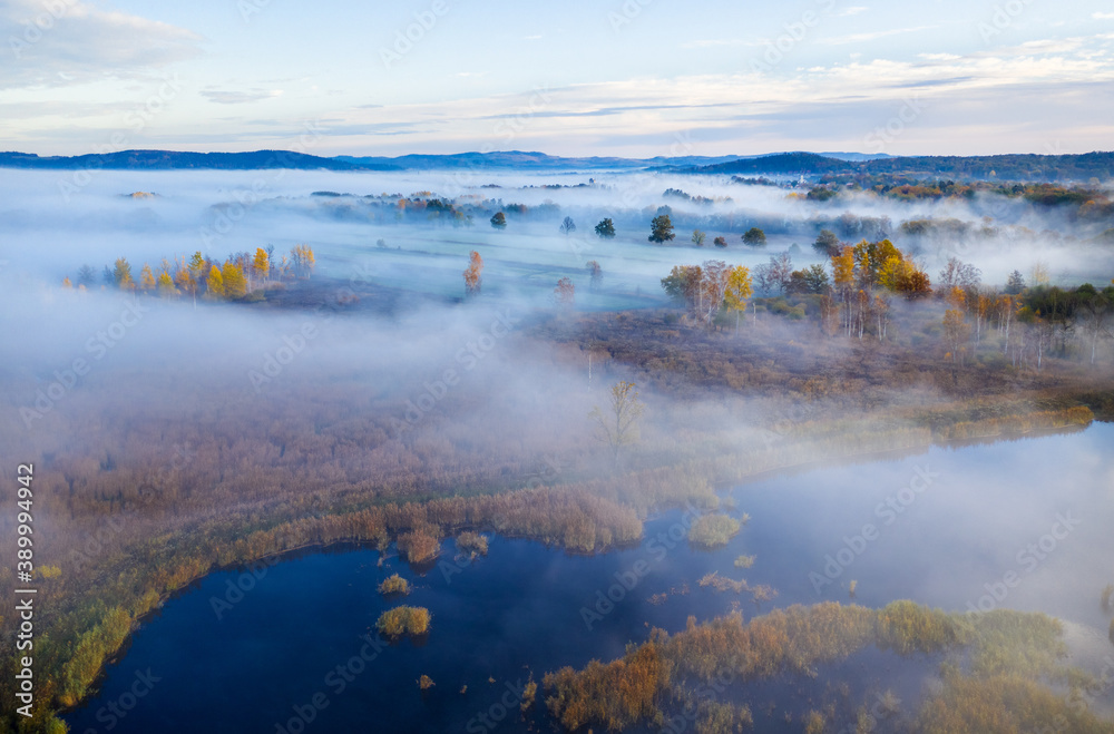 Beautiful aerial view of morning fog and sunrise in autumn forest.