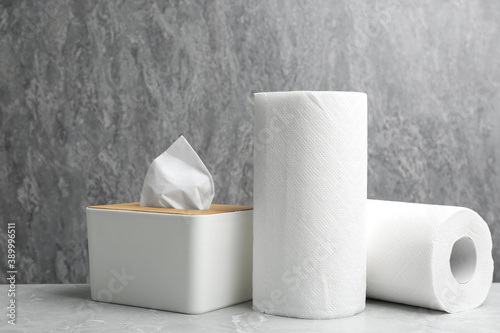 Rolls of paper towels and tissues on marble table photo
