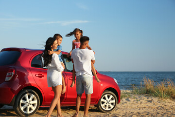 Happy family near car on sandy beach. Summer trip