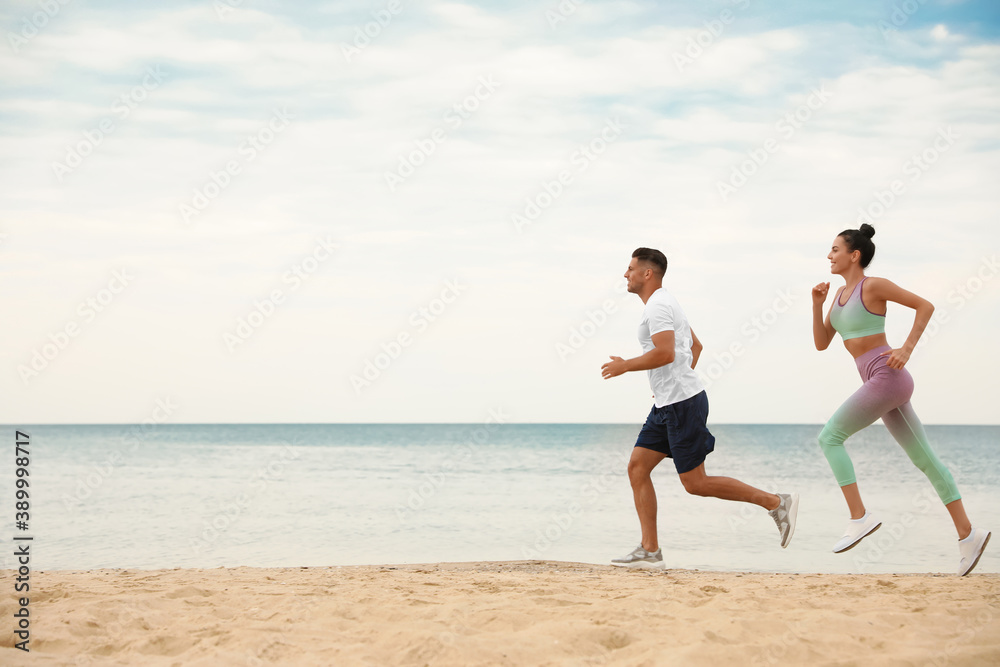 Couple running together on beach, space for text. Body training Couple running together on beach, space for text. Body training