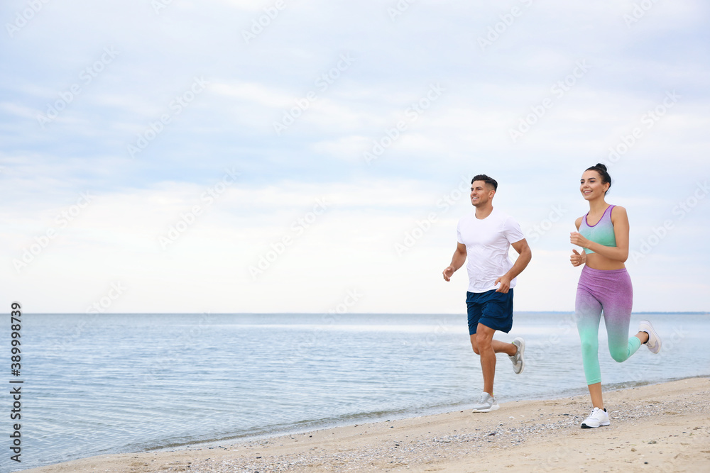 Couple running together on beach, space for text. Body training Couple running together on beach, space for text. Body training