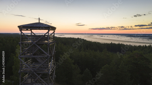 фотографія Aerial view to the wooden watchtower with the woodland and fog clad twilight bog